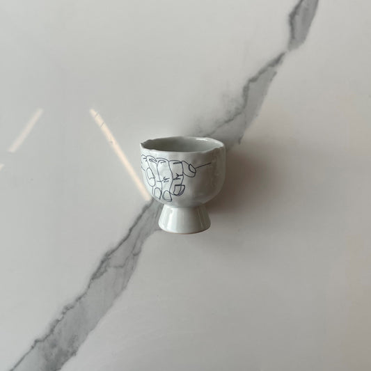 Stemmed cup with abstract hands
